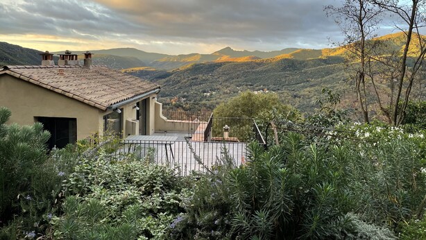 A house with a tiled roof, a balcony, and a view of a mountainous landscape. - A Mas in the Parc des Cévennes with breathtaking views over the Hérault valley (Saint Julien de la nef)