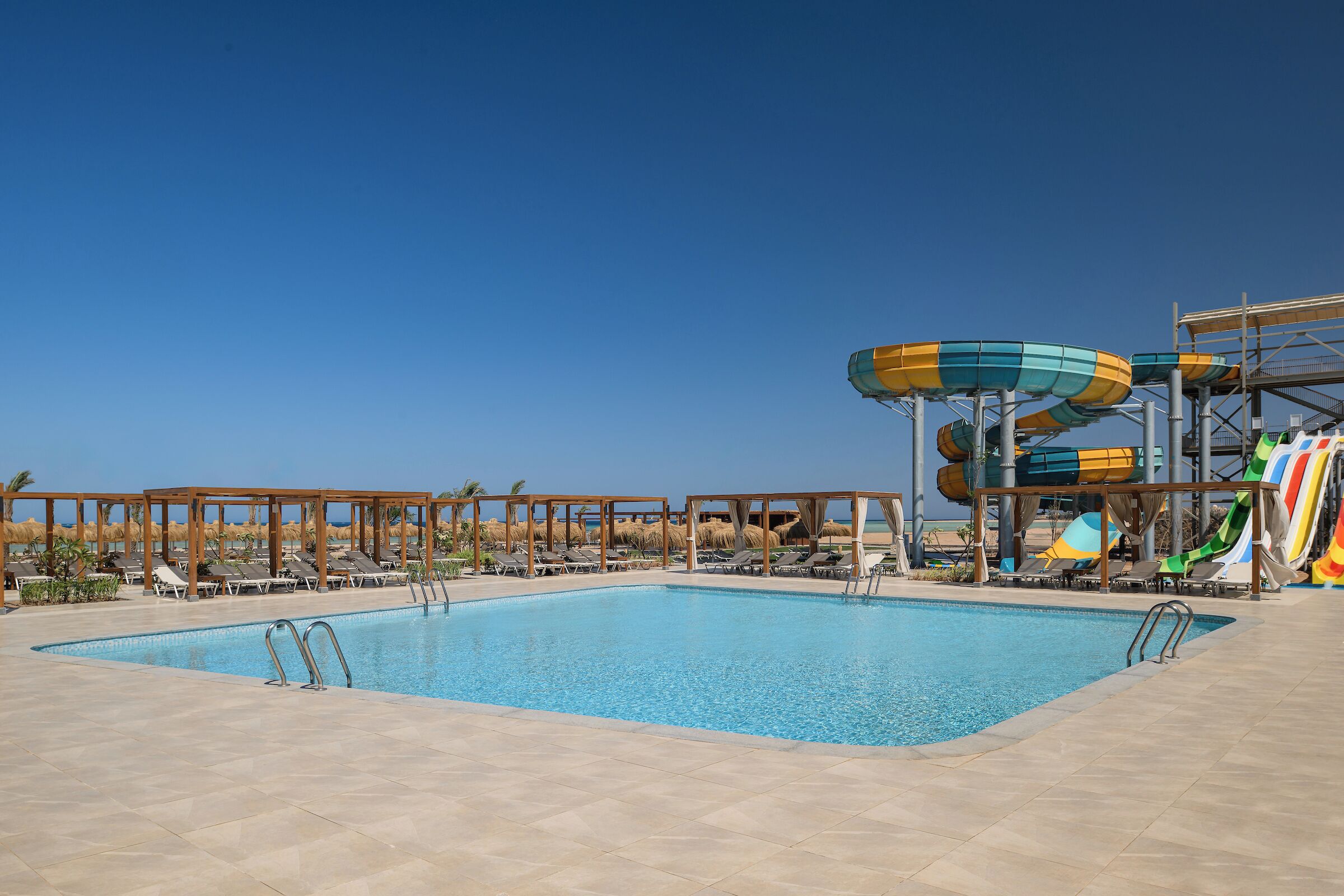 A swimming pool with water slides and sun loungers.