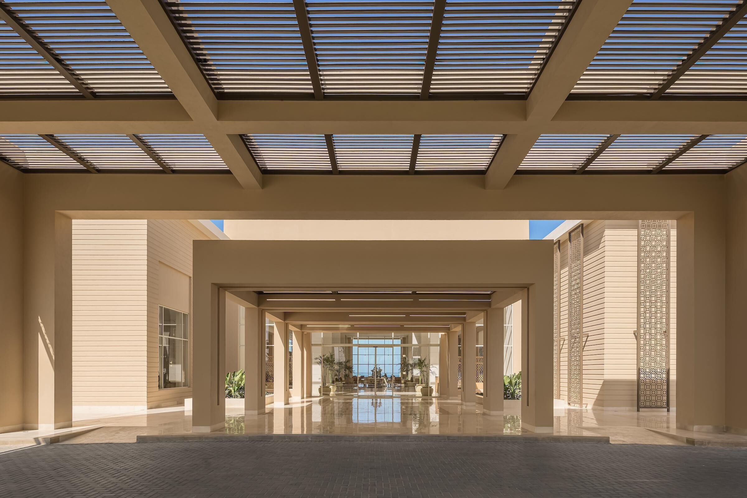 A spacious lobby with a high ceiling, large windows, and a reflective floor.