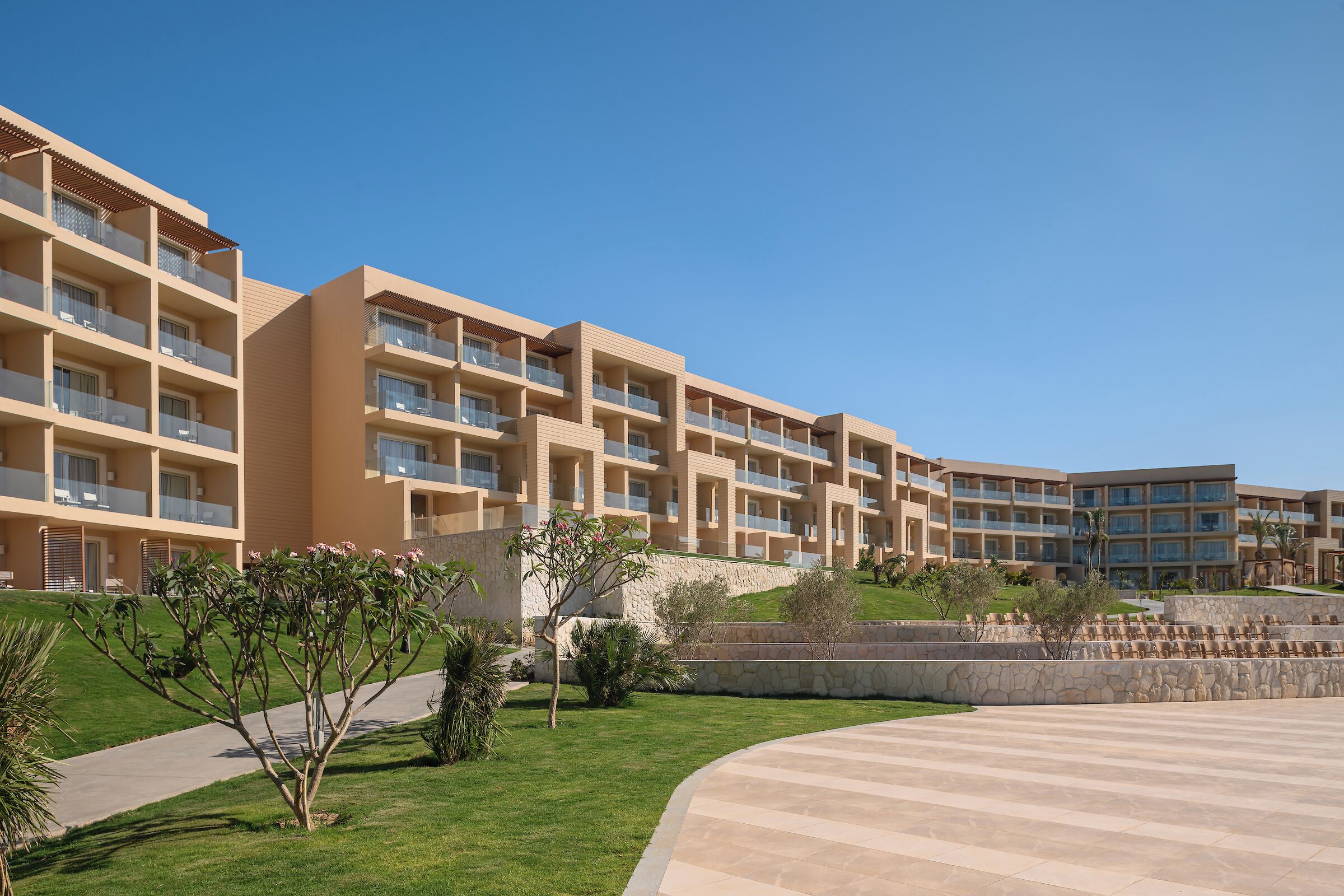 Un hôtel moderne doté de nombreux balcons, d’un jardin aménagé et d’un espace piscine.
