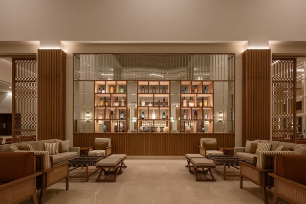 A modern interior with a central display of decorative items, cushioned seating, and wooden paneling.