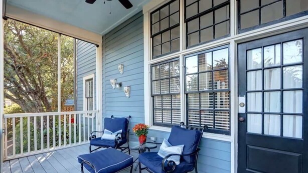 A porch with two blue chairs, a small table, and a potted plant. - Avery's Cottage @ Trustees' Garden | Walk 2 River! (Savannah)