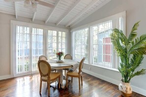 A dining area with a round table, four chairs, and a potted plant. - Avery's Cottage @ Trustees' Garden | Walk 2 River! (Savannah)