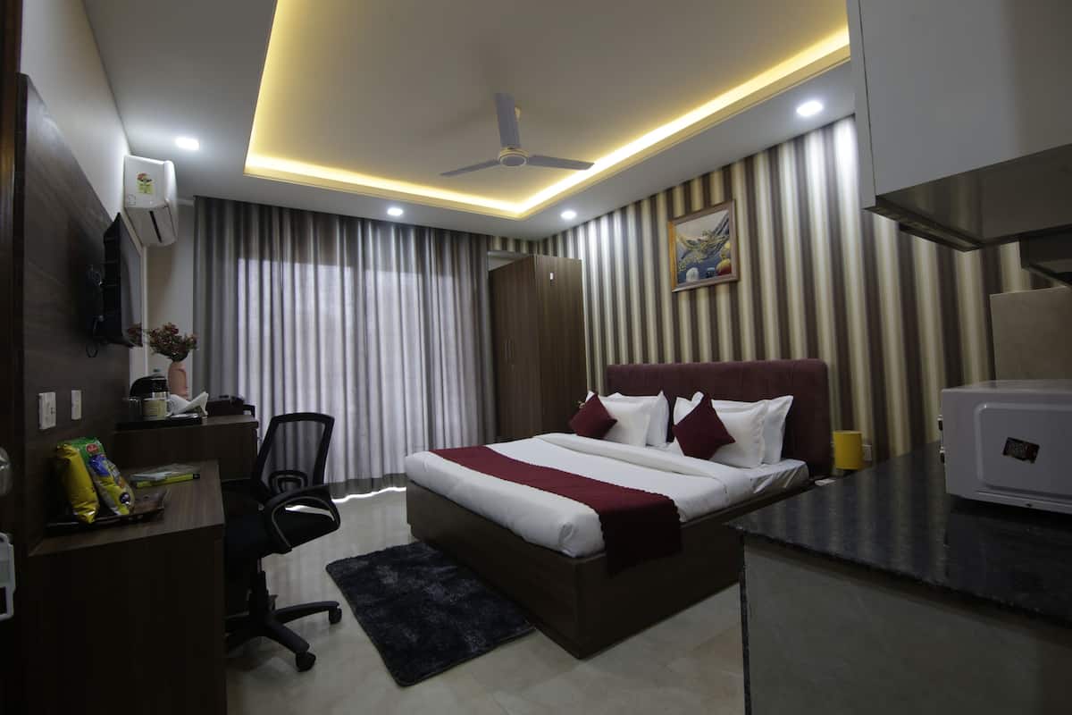 Une chambre d’hôtel équipée d’un lit, d’un bureau, d’une chaise et d’un four à micro-ondes.
