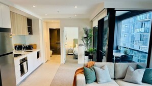 Un apartamento moderno con cocina, sala de estar y balcón con vistas a la ciudad.