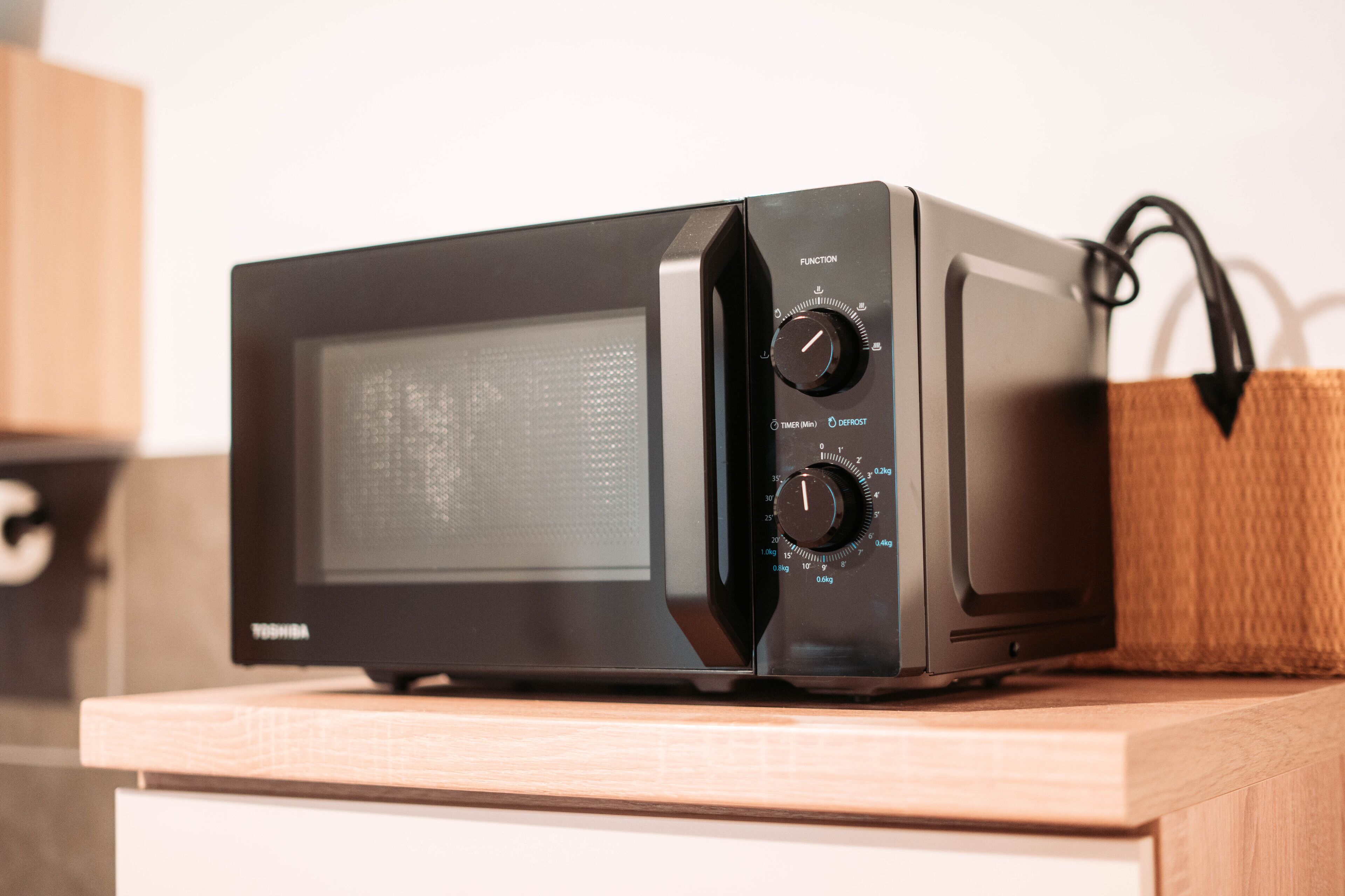 Un horno microondas Toshiba sobre una encimera de madera.