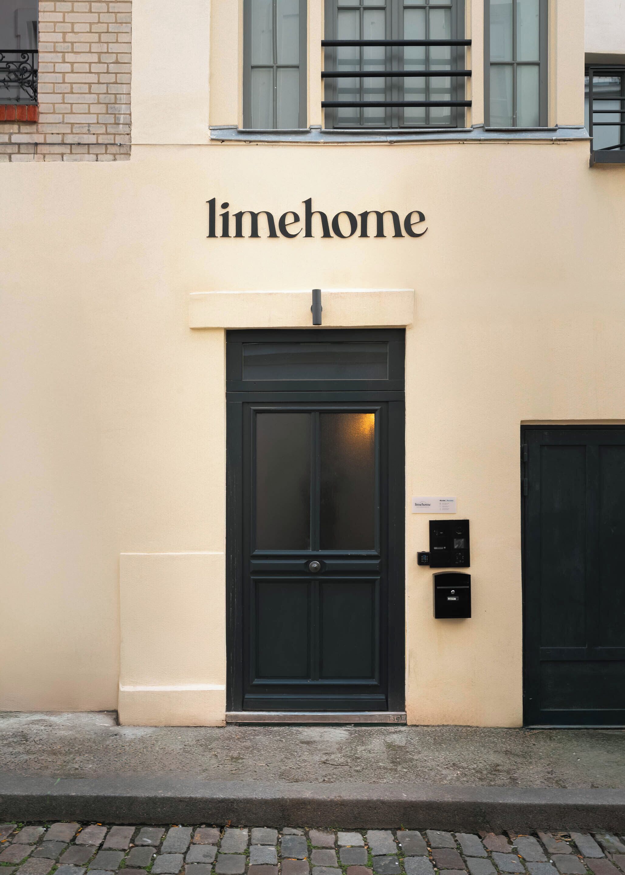 A building facade with a black door and the name 'limehome' above it.
