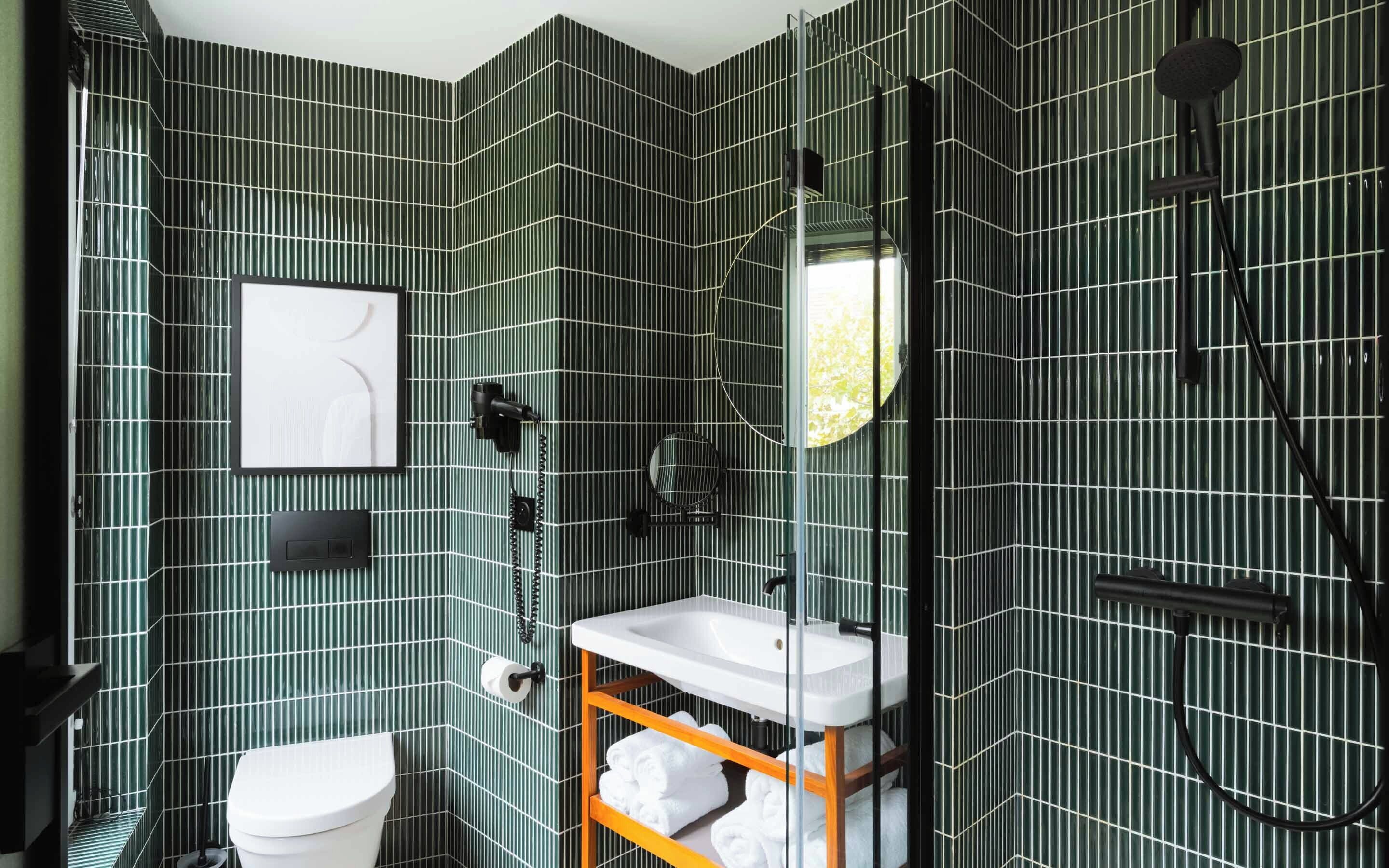 A bathroom with a modern design, featuring a toilet, sink, and shower area.