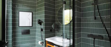 A bathroom with a modern design, featuring a toilet, sink, and shower area.