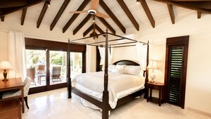 A four-poster bed with a canopy, wooden headboard, and bedside tables with lamps.