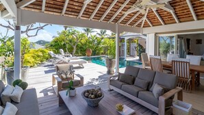 Un espace extérieur abrité comprenant une piscine, des chaises longues et une table à manger.