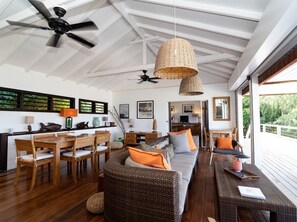 Relax in this stylish space with a comfortable sofa, dining table, and balcony overlooking lush greenery.