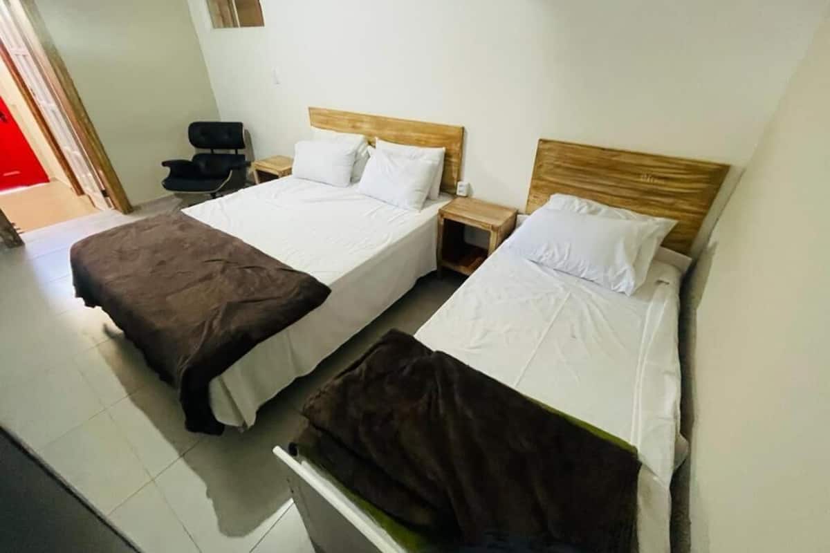 Une chambre avec deux lits, une chaise et une petite table.