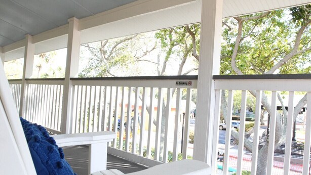 A covered porch with white railings and a 'No Smoking' sign. - Cozy Apartment Overlooking Downtown Dunedin (Dunedin)