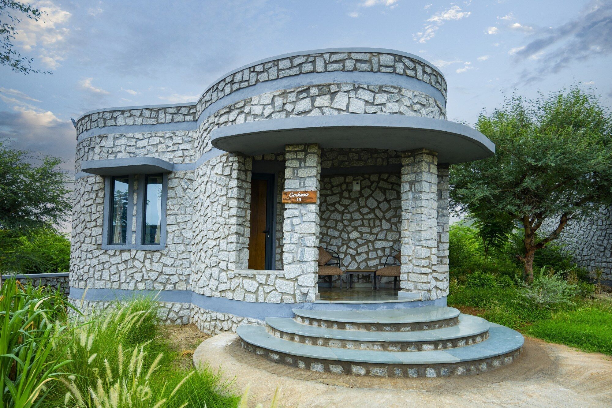 A stone building with a circular entrance and a sign reading "Godana 19".