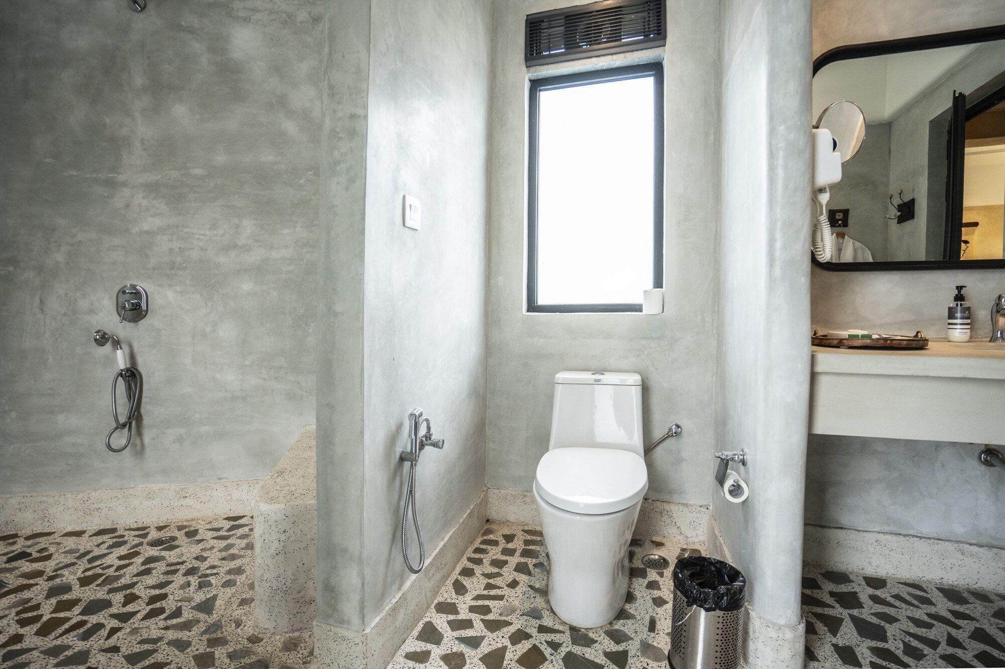 A bathroom with a toilet, a shower, and a sink.