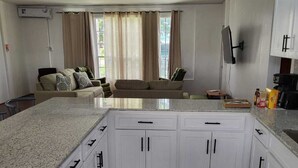 Una cucina moderna con mobili bianchi, un piano di lavoro in granito e una grande isola.