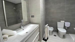Et moderne badeværelse med et stort badekar, toilet og bidet.