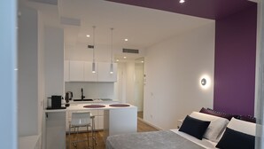 A modern bedroom with a bed, a small kitchenette, and a dining area. - Me too - Exclusive Apartments Studio Open Space Room 1 (BARI)