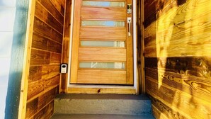 A wooden door with a glass panel and a handle, leading to a concrete staircase. - 4 BR/2 BA walking distance to AT&T, Ranger Stadium, Texas Live, Six Flags (Arlington)