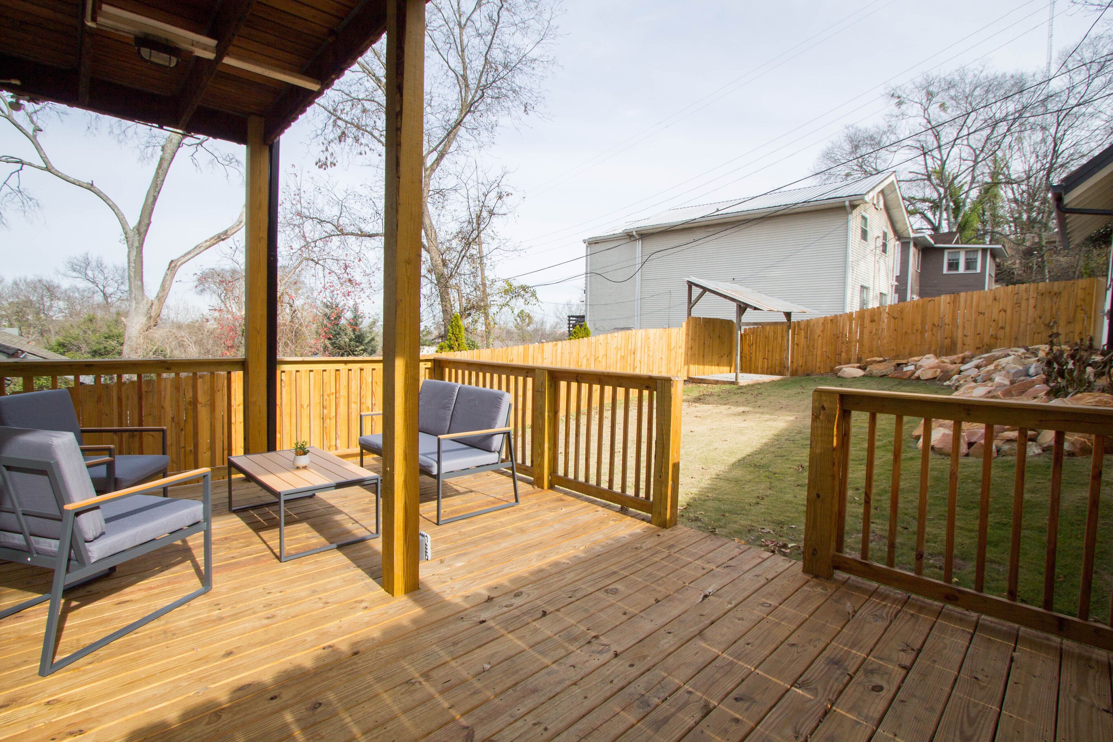 A wooden deck with outdoor furniture and a covered area.