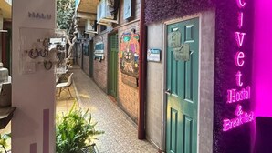 A hallway leading to a hostel with a neon sign indicating it offers breakfast. - HOSTAL VELVET  (Santa Ana)