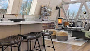 Een moderne keuken met een groot eiland, barkrukken en een open haard.