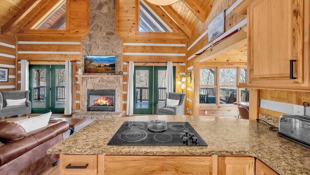 Un chalet spacieux doté d’une grande cuisine, d’une cheminée en pierre et d’un intérieur en bois.