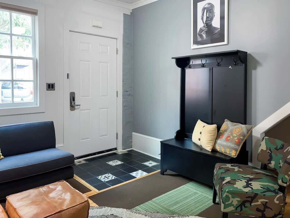 A living room with a blue sofa, a black cabinet, and a patterned rug.