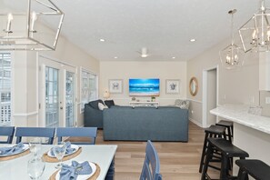 A modern living room with a sofa, dining table, and bar area.