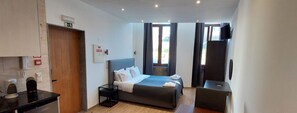 A modern hotel room with a bed, bedside table, and a TV. - NEW LIFE - FUNDACAO SERRALVES STUDIO-0F (Porto)