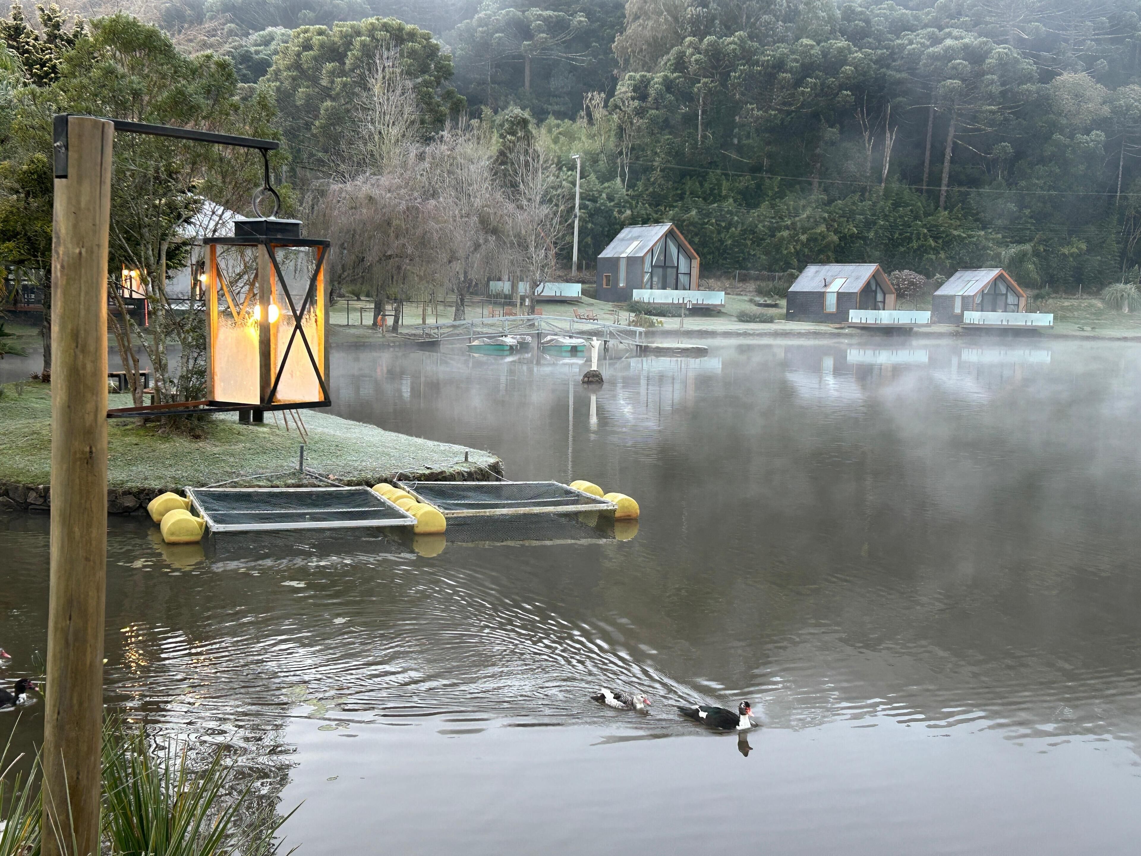 Un entorno tranquilo junto al lago, con muelles de madera, un farol y casas al fondo.