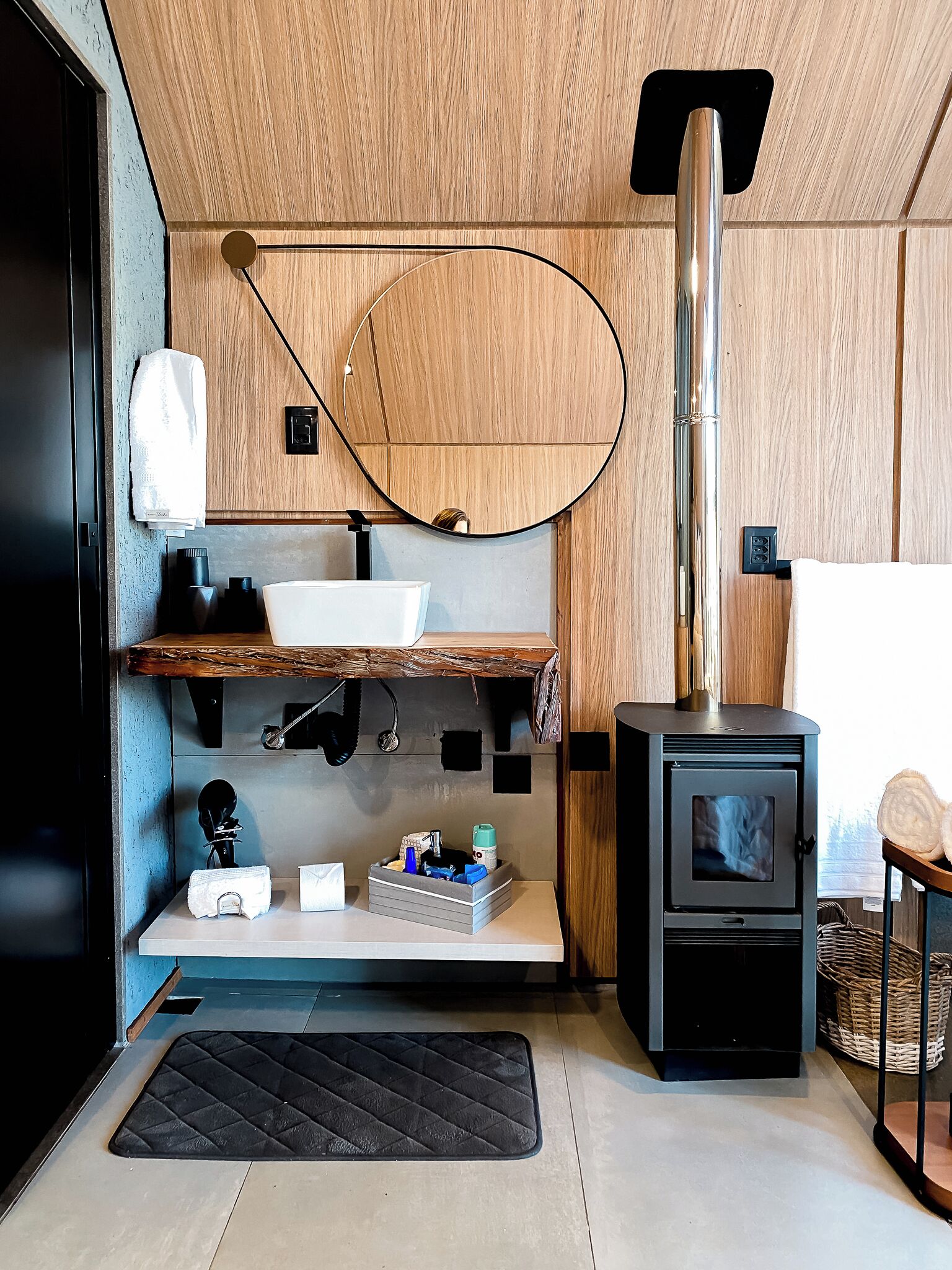 Une cuisine compacte dotée d’un plan de travail en bois, d’un évier, d’une cuisinière et d’un miroir.
