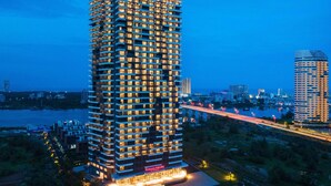 A tall, modern hotel with multiple floors, illuminated windows, and a prominent sign at the top.