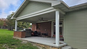 A house with a covered patio, a grill, and a brick fireplace. - A Stylish 2+ Bedroom Rancher (Clifton Forge)