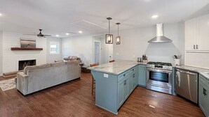 A spacious kitchen with a central island, built-in appliances, and a dining area with a sofa and chairs. - Lake Greenwood Home -- Come refresh in a quiet cove!  (Greenwood)