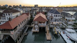 A marina with docked boats and a central building with a red roof. - The Capone House | Historic Luxury on the Bay (Atlantic City)