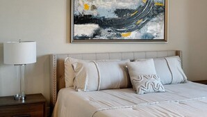 A bedroom with a bed, pillows, a bedside table, and a lamp. - 3-Story Downtown Houston Safe Haven (Houston)