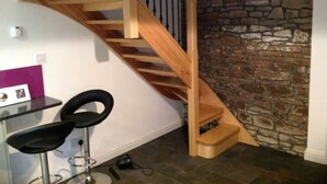 A staircase with wooden steps and a stone wall.