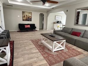 A living room with a sofa, coffee table, and a ceiling fan.