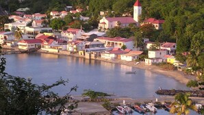 A coastal town with buildings along the waterfront, a prominent tower, and a marina with boats.