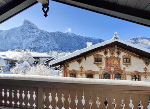 Un bâtiment à l’architecture riche et élaborée, avec une chaîne de montagnes en toile de fond.