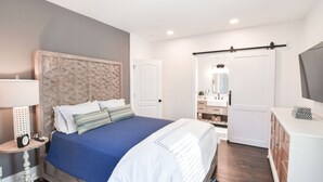 Un dormitorio con cama, mesita de noche, lámpara y armario.
