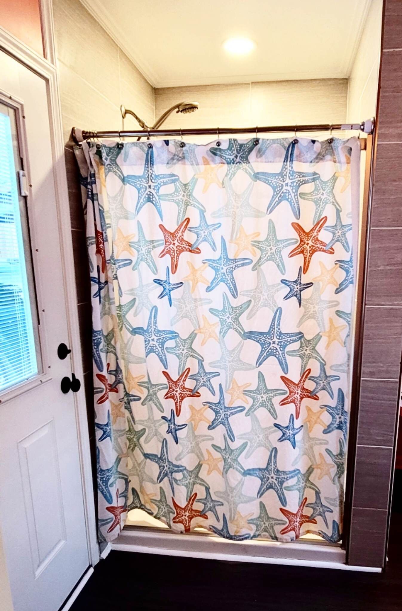 Une salle de bain avec un rideau de douche orné d’un motif d’étoile de mer.