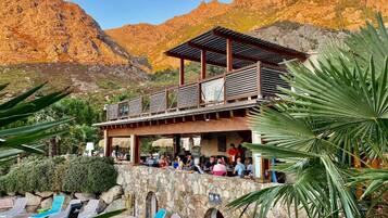 Un restaurant doté d’une terrasse offrant une vue sur un paysage montagneux.