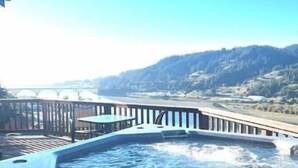 Un bain à remous avec vue sur un pont et des collines en arrière-plan.