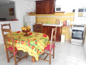 Kjøleskap, kjøkkenutstyr og spisebord