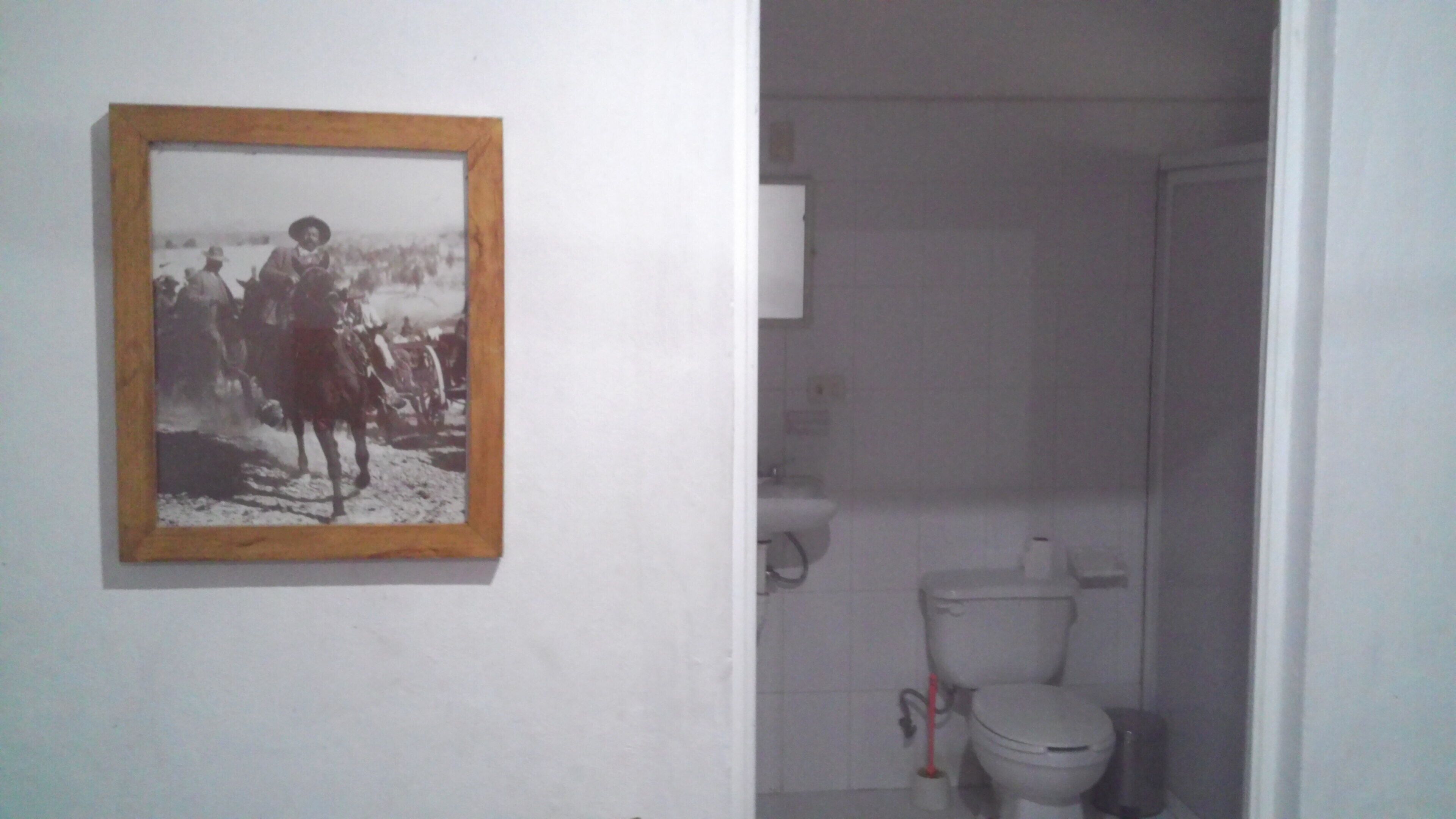 Ein Badezimmer mit Toilette, Bidet und einem gerahmten Foto an der Wand.