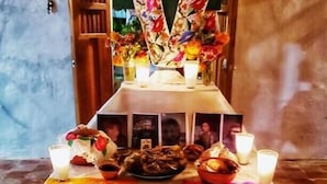 A table with food and drinks, decorated with candles and a floral arrangement. - Casa de Toj2 (Chicxulub Pueblo)