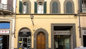 En bygning med en stor trædør, en pengeautomat og en butik med skiltet "Hair Flo".
